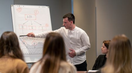 business conference or meeting in a hotel a man on a flipchart shows a development plan for company